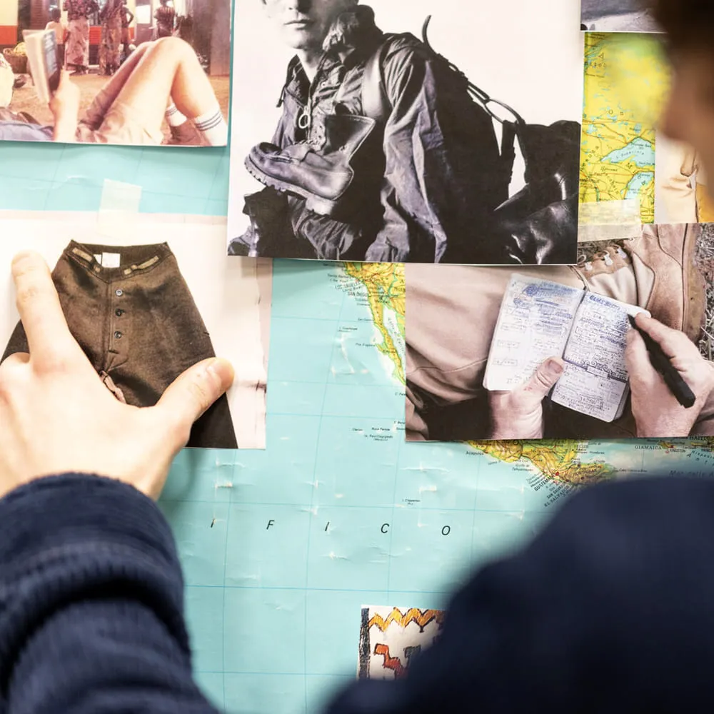 Studente che compone un moodboard con fotografie e una mappa geografica